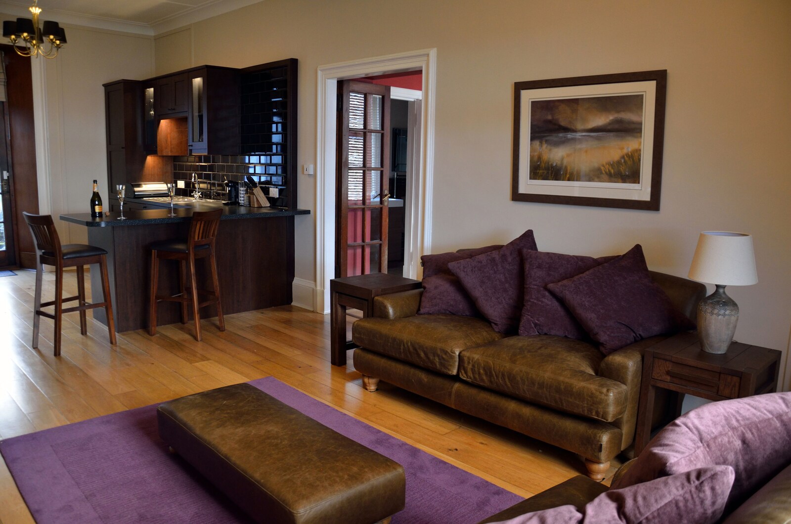 Apartment living room with leather seating and open-plan kitchen